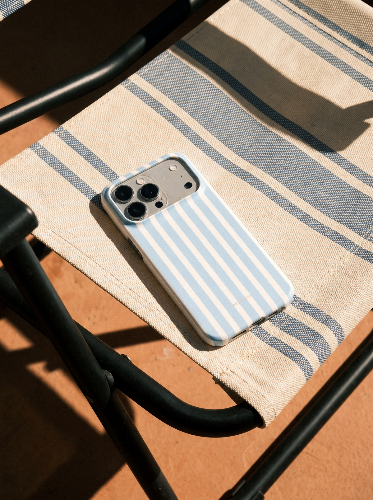 Portofino striped phone case on a sunlit beach chair
